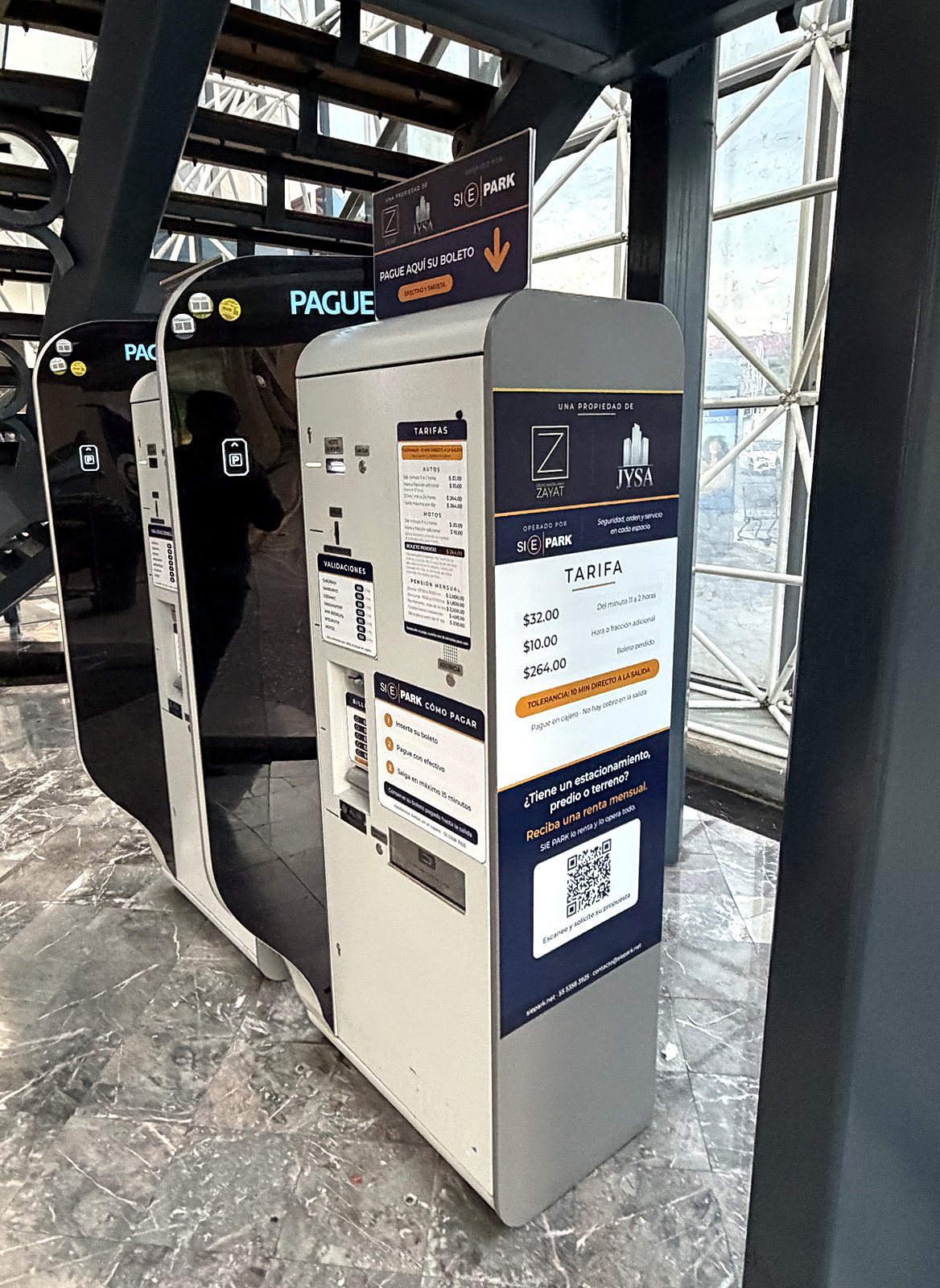 Fila de cajeros de pago automático con tarifas y validaciones publicadas